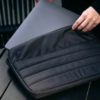 Laptop being inserted into custom branded Repreve recycled laptop sleeve, employee welcome kit merch by Wumble Merch Australia