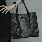 Person carrying custom branded Tyvek work bag on shoulder, employee welcome kit merch by Wumble Merch Australia